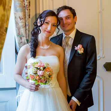 Hochzeit-in-Moeckmuehl-Schloss-Assumstadt-glueckliches-Brautpaar-mit-Brautstrauß-stehend-Hand-in-Hand-am-Fenster-Fotograf-Natalja-Frei-